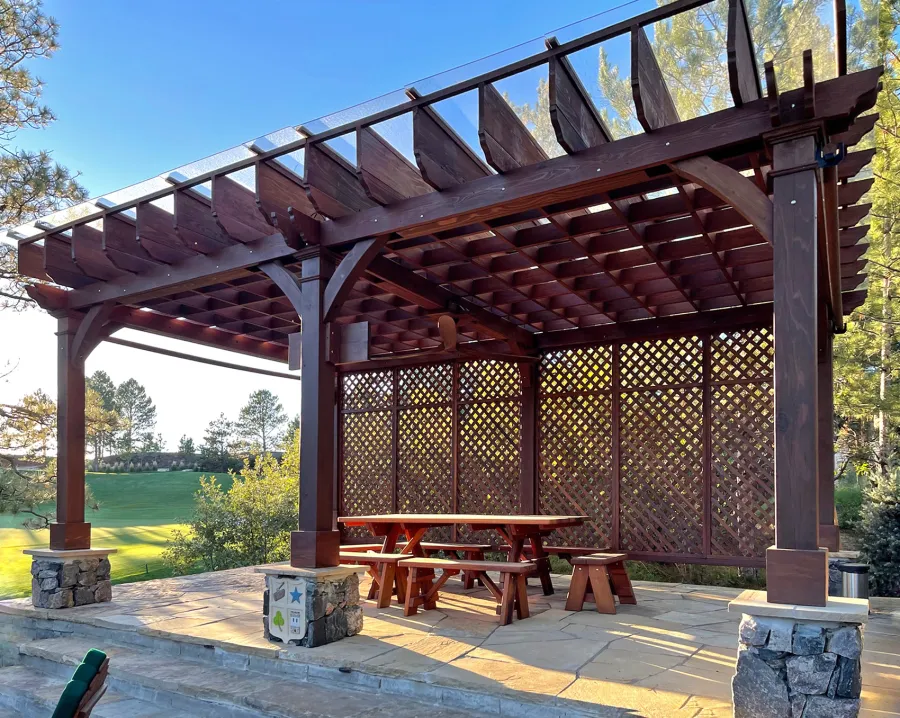 Montvale Pergolas (Options: 24' x 16', Mature Redwood, 6-Post Anchor Kit for Concrete, 1 Ceiling Fan Base and 1 T.V. Base, 2 Curtain Rods, 1 Lattice Privacy Panel, 9.5' H Posts, with Rain Guard, Coffee-Stain Premium Sealant). Photo Also Shows Some Adirondack Chairs with Ottoman. Photo Taken 1 Year After Installation, and After Restaining. Photo Courtesy of J. Brinkman of Castle Rock, Colorado.