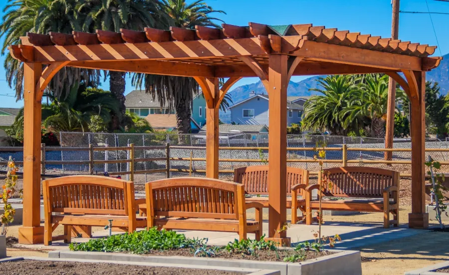 Montvale Pergolas (Options: 16' x 20', Mature Redwood, 4-Post Anchor Kit for Concrete, No Ceiling Fan Base, No Curtain Rods, No Privacy Panels, 9.5' Post, Transparent Premium Sealant). Photo also shows some Luna Memorial Benches and Lighthouse Benches. Sunbrella shade fabric above the pergola was ordered from: www.patiolane.com as a custom item. Photo Courtesy of Carpinteria Park, 5775 Carpinteria Avenue  Carpinteria, CA  93013.