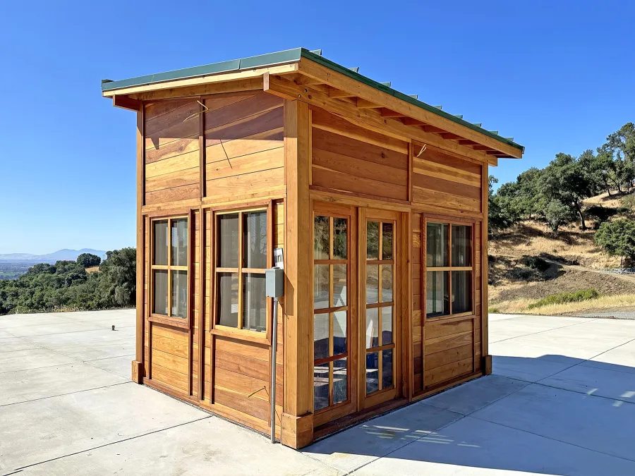 Palo Alto Backyard Cabin (Options: 10' L, 12' W, Without Porch, California Redwood for Exterior Finished, Douglas-fir Internal Walls and Framing, With 2 French Doors, Slidding Windows, Windows Purchased Locally, With 4' x 4' Skylight, Metal Roof, Electrical Wire Trim on the Walls, Transparent Premium Sealant). Photo Courtesy of M. Diaz of Fairfield, CA.