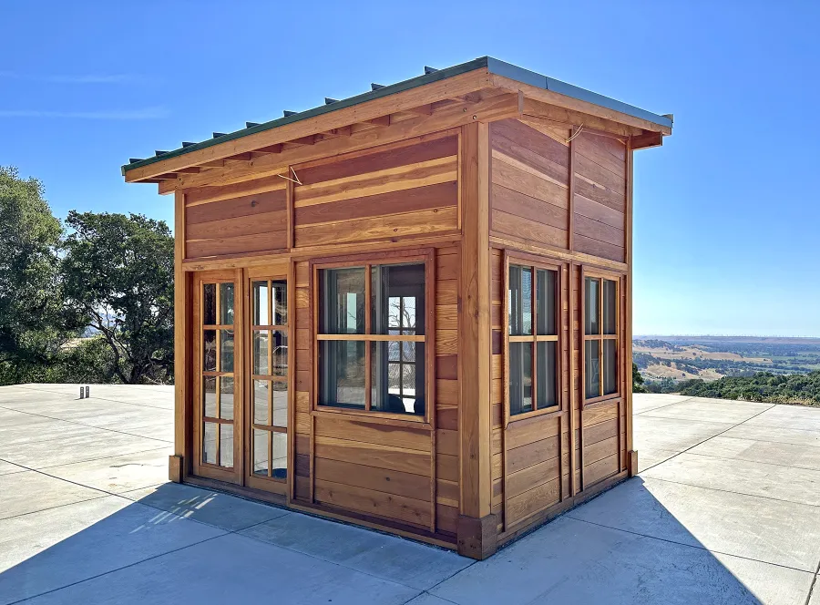 Palo Alto Backyard Cabin (Options: 10' L, 12' W, Without Porch, California Redwood for Exterior Finished, Douglas-fir Internal Walls and Framing, With 2 French Doors, Slidding Windows, Windows Purchased Locally, With 4' x 4' Skylight, Metal Roof, Electrical Wire Trim on the Walls, Transparent Premium Sealant). Photo Courtesy of M. Diaz of Fairfield, CA.