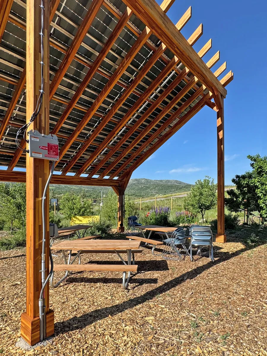 Solar Pergola (Options: 23' L x 18' W, Mosaic California Redwood, 12:7 Pitch, Post Anchor Kit for High-Wind, Transparent Premium Sealant). Pergola Installed in Colorado Mountain College in Steamboat Springs, CO.