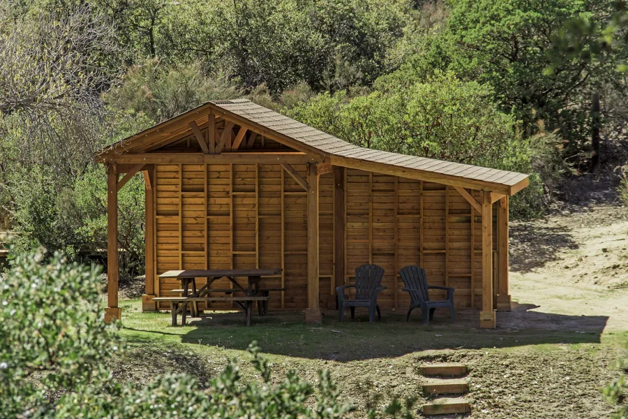 Sunset Patio Pavilion Attached to a 12' x 12' Del Norte Pavilion (Options: 9' x 12', Douglas-fir, No Ceiling Fan Base, No Electrical Wiring Trim Kit, 2-Post Anchor Kit for High-Wind, with Custom Solid Wall, Transparent Premium Sealant). Photo Courtesy of J. Randall of Warner Springs, CA.