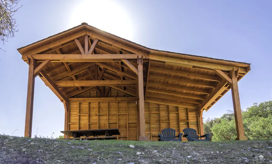 Sunset Patio Pavilion Attached to a 12' x 12' Del Norte Pavilion (Options: 9' x 12', Douglas-fir, No Ceiling Fan Base, No Electrical Wiring Trim Kit, 2-Post Anchor Kit for High-Wind, with Custom Solid Wall, Transparent Premium Sealant). Photo Courtesy of J. Randall of Warner Springs, CA.