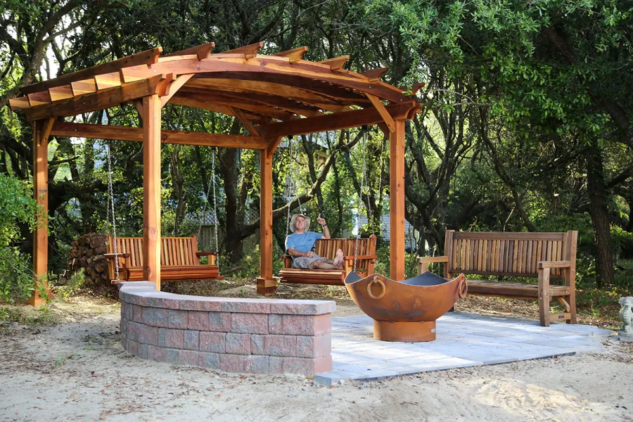 Ti Amo Benches (Options: 6 ft, California Redwood, No Cushion, No Engraving, Transparent Premium Sealant). Photo Also Shows an Arched Pergola with Bench Swing Seats. Photo Courtesy of Tom Marten of Kitty Hawk, North Carolina.