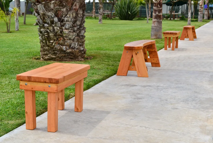 Wood Patio Bench (Options: 3 1/2 ft x 14 1/4 inches W x 18 1/2 inches H, Douglas-fir, No Cushion, No Engraving, Cherry Stain Premium Sealant). Photo also shows some round picnic benches.