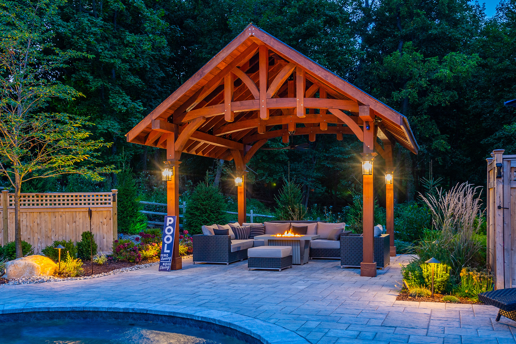 The Granada Pavilion lit at dusk beside a pool