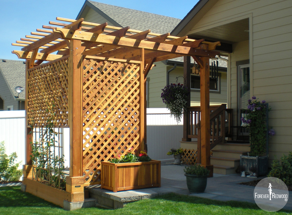 Traditional Wooden Garden Pergola (Options: 10' L x 12' W, California Redwood, No Electrical Wiring Trim, Open Roof with Slats at 18", Rafters at 18", Widthwise Roof Support Timbers, 4-Post Anchor Kit for Stone, No Ceiling Fan Base, 3 Privacy Panels, No Curtain Rods, 9' Post Height, Transparent Premium Sealant). Photo Courtesy of Bill and Sandy Gibson of Coeur d'Alene, Idaho.